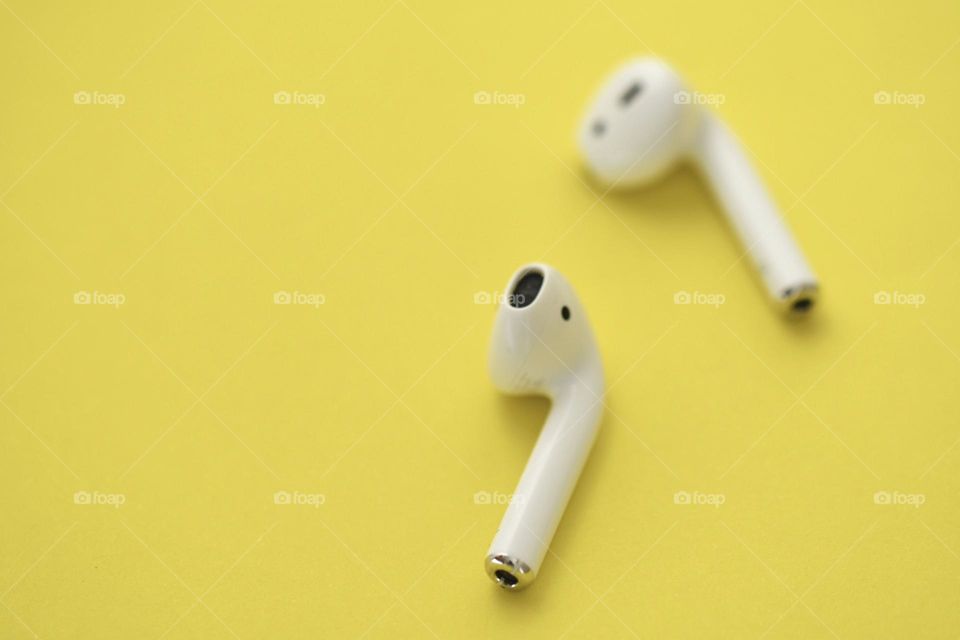 Photo of earphones on yellow background 