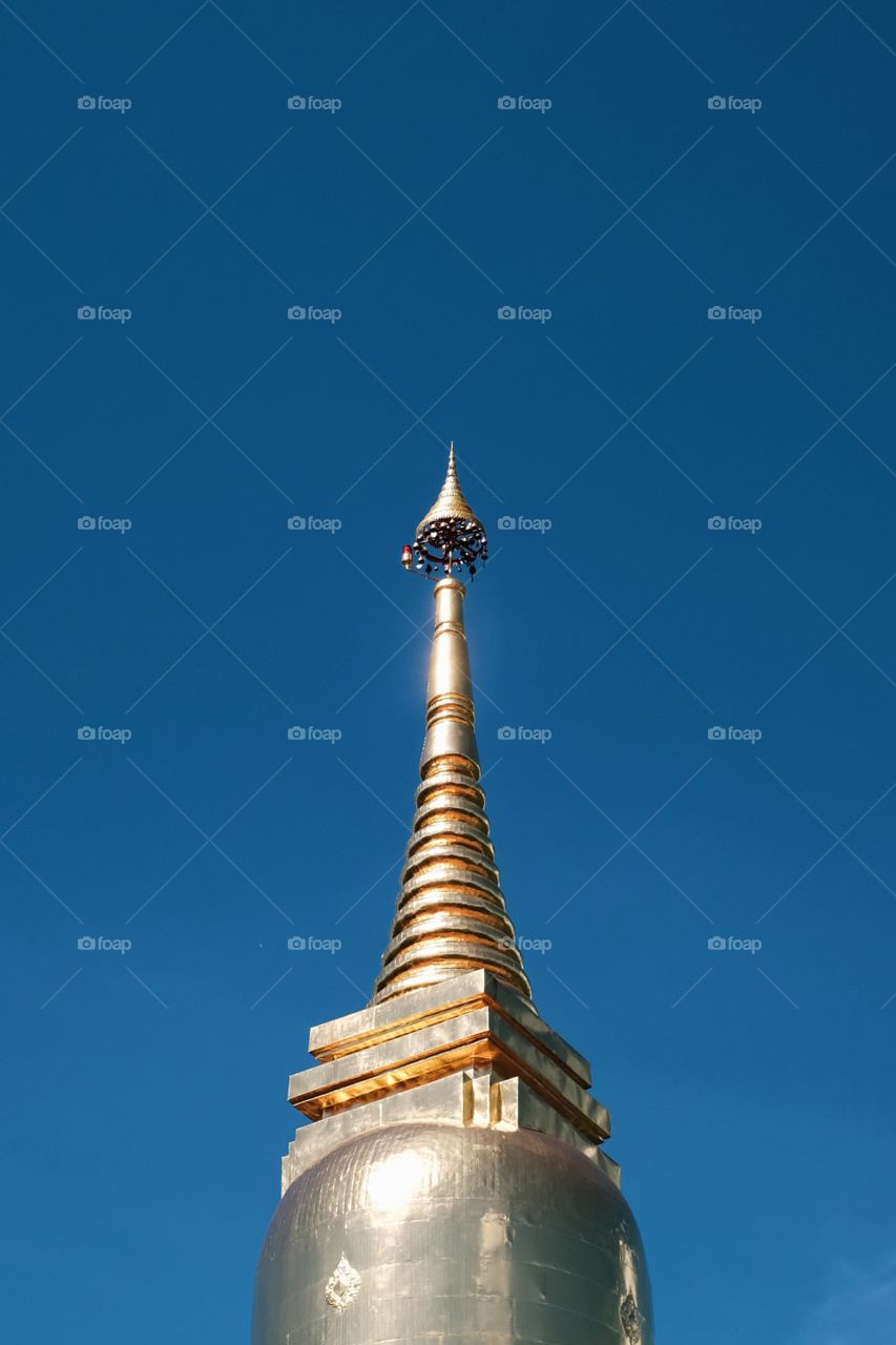 Golden pagoda top blue sky background