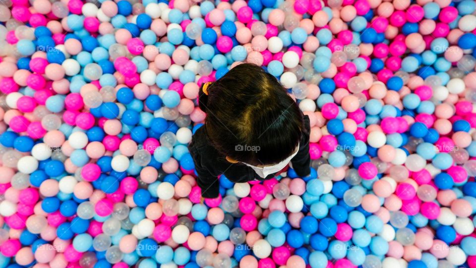 standing in a pool of toy balls