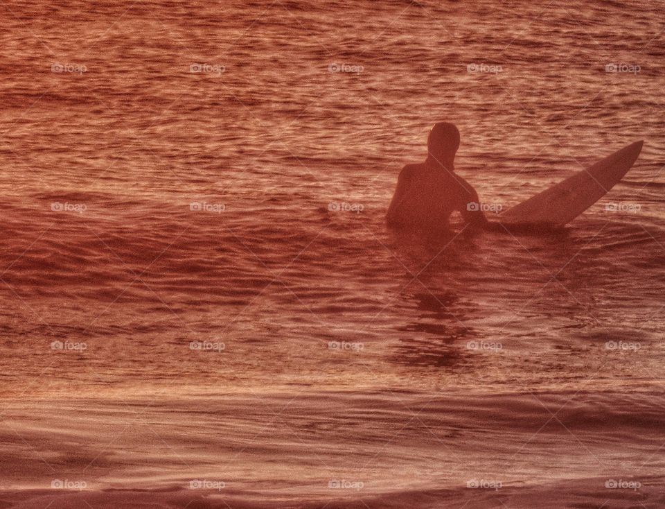 California surfer in twilight waters of Half Moon Bay