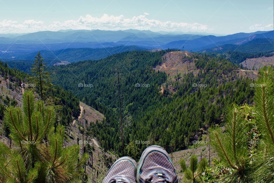 Beautiful view Merlin, Oregon; woman sitting with shoes on the edge up on the logging trails