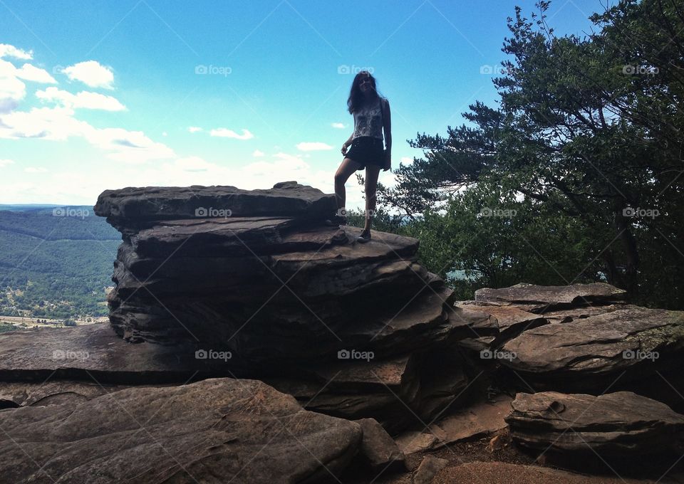 Happy girl standing on rock