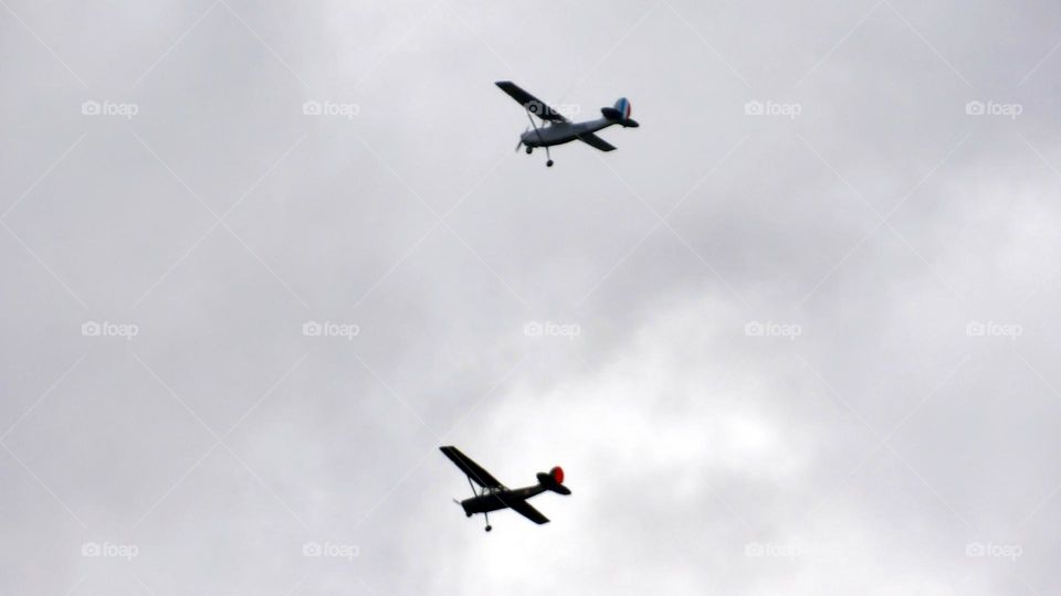 Two mono wing planes with grey cloudy background in parallel formation