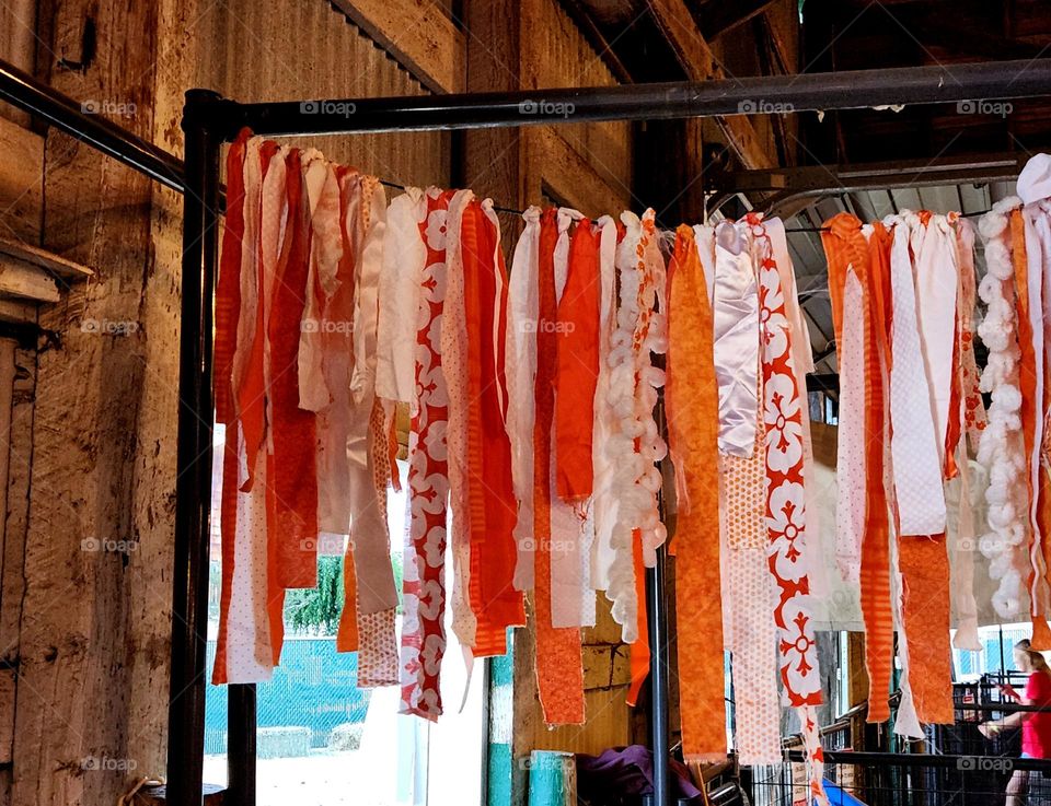 long orange and white fabric ribbon display in a wooden barn at an Oregon County fair