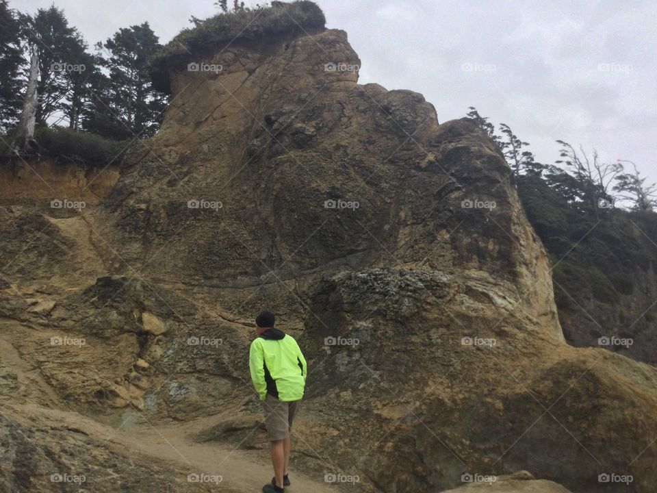Rock Formations at Hug Point in Oregon with a person walking up them
