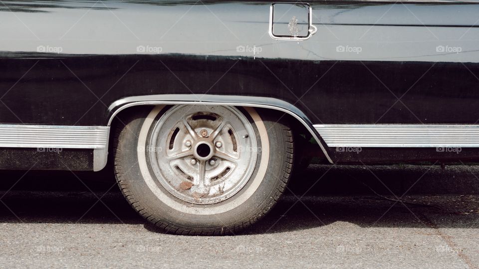 close up vintage retro car wheel black finish round tire shadow