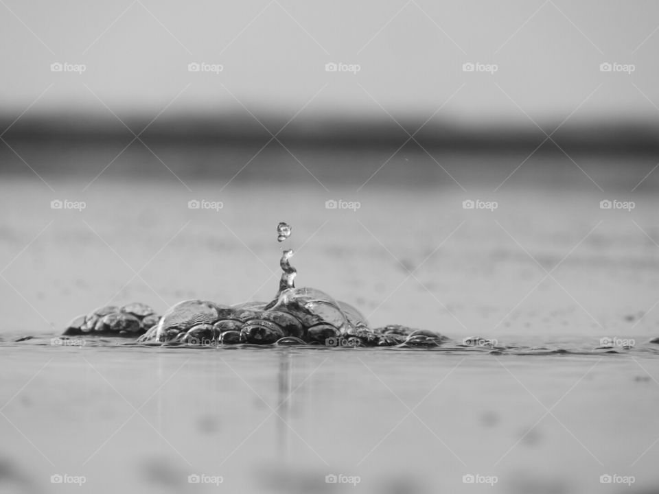 The fluid motion of water captured as it bursts forth from the sand.