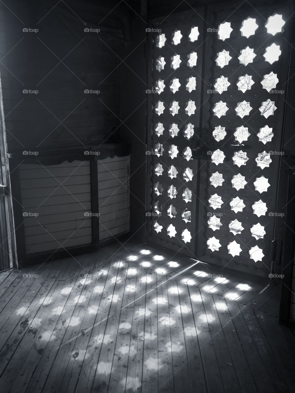 Light through the star holes of an ancient wooden gate