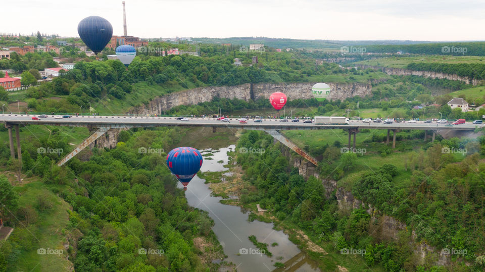 Hot air balloon under the bridge in the canyon 