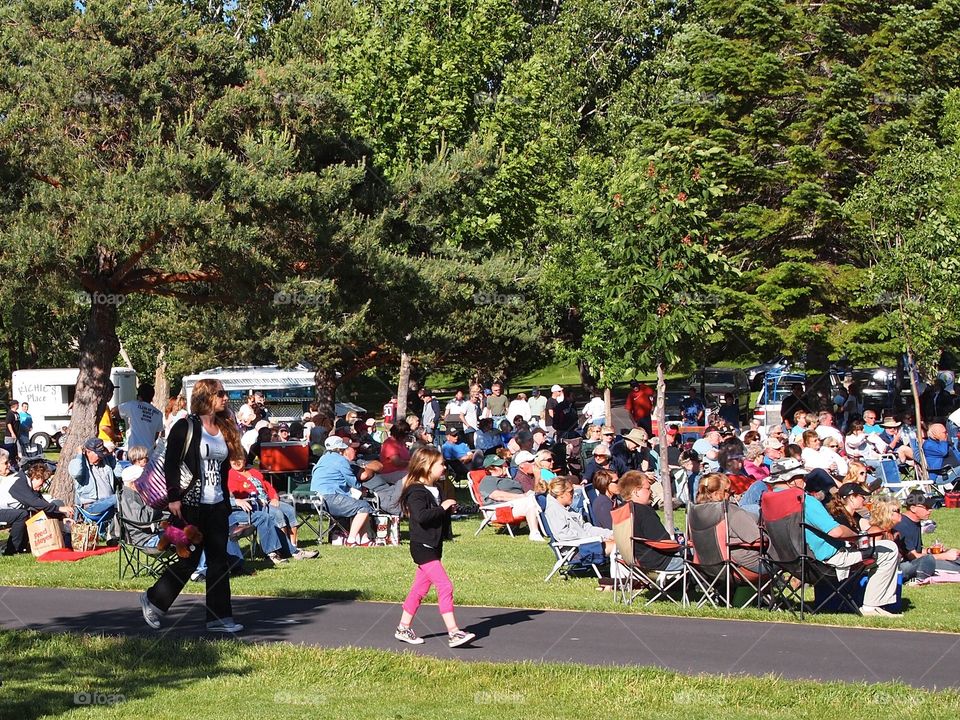 People in Sam Johnson Park in Central Oregon waiting for a show on a summer evening. 