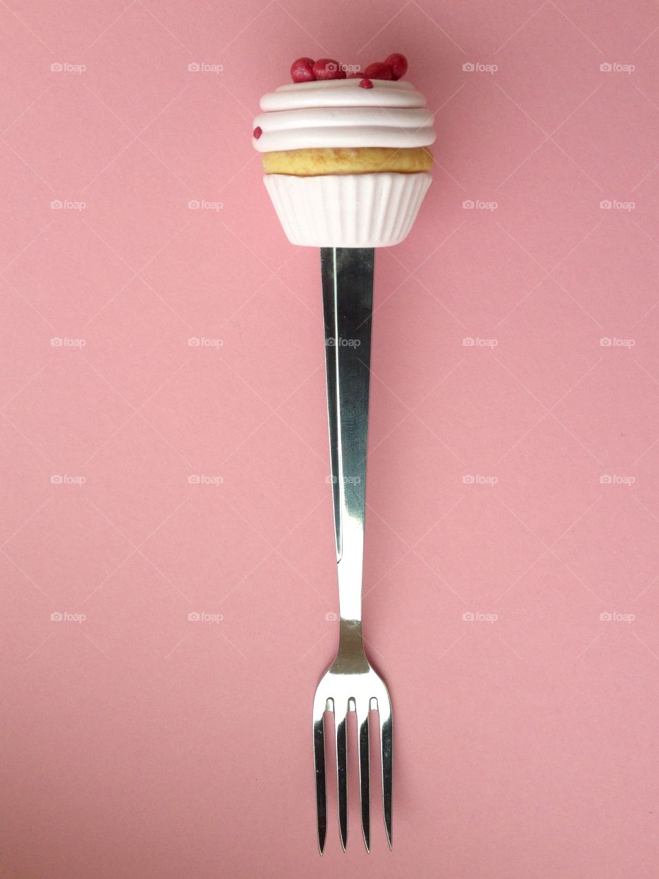 Fork with cake on pink background 