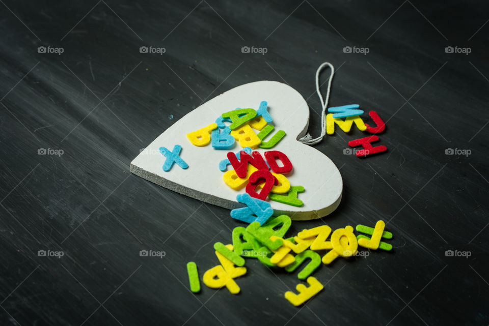 wooden table with white wooden heart and colorful letters