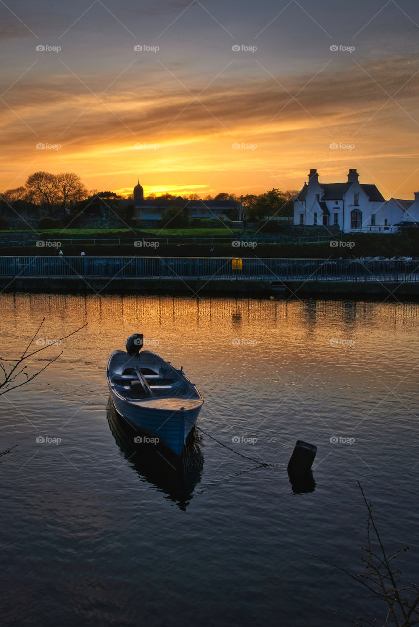 Boat at sunset in galway city on the corrib river