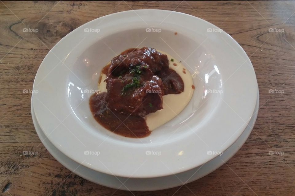 Meat dish with cream sauce on a wood table