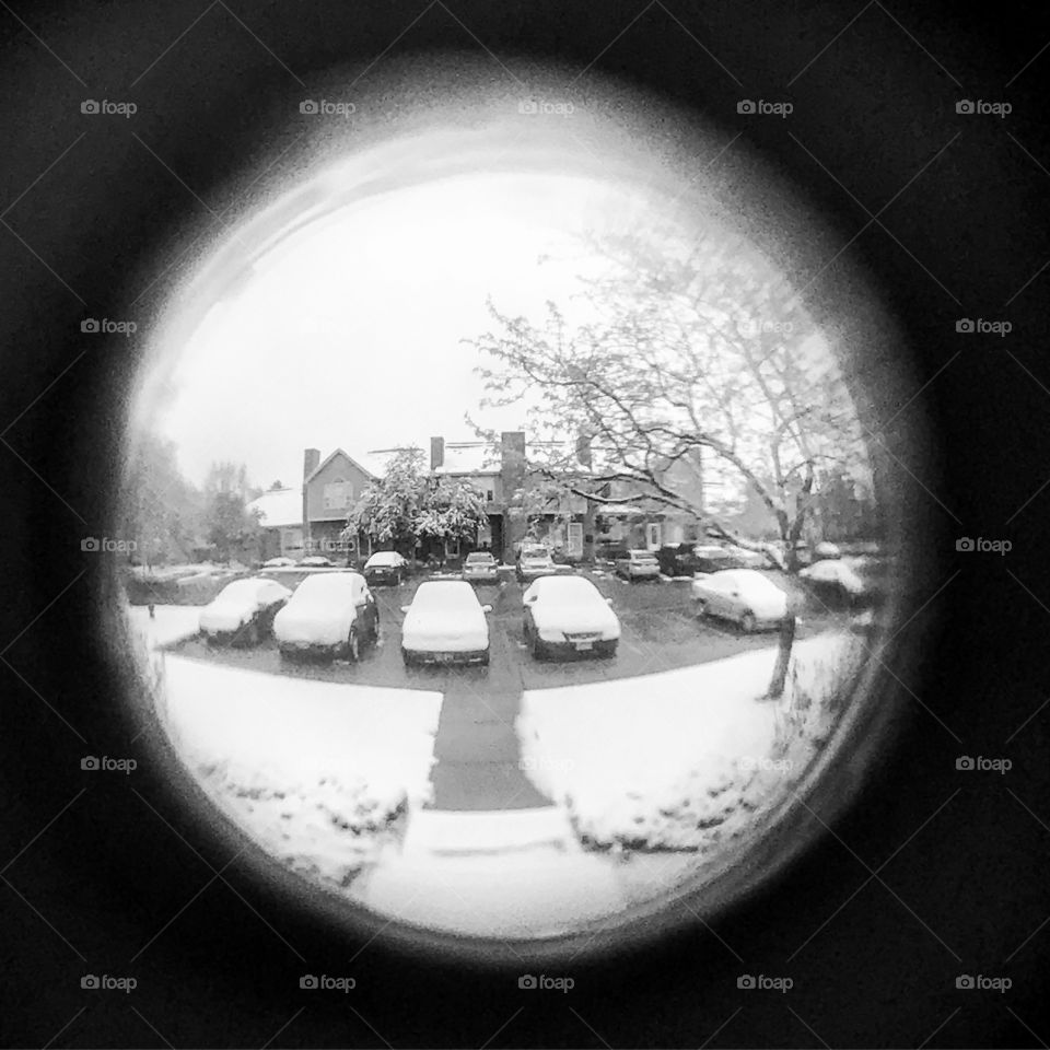 Pinhole look through to a snowy suburban porch.