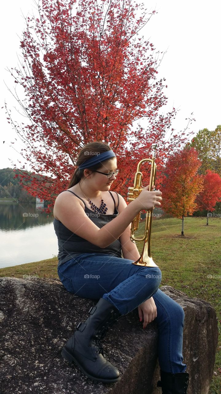 the trumpet player. playing at the lake