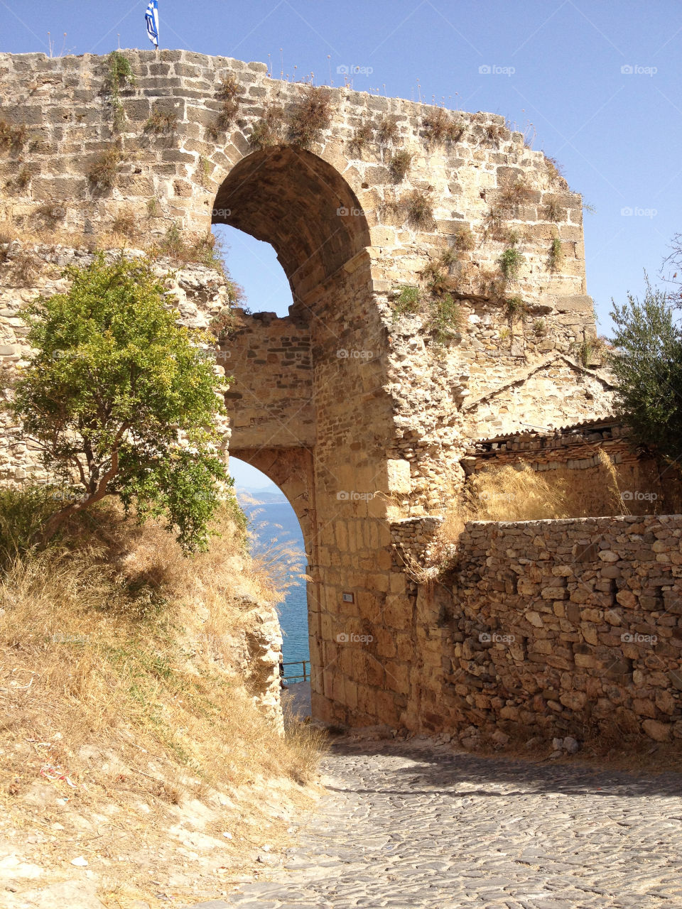Entrance to the castle in Koroni, Greece with a slight view of the beautiful blue waters below 