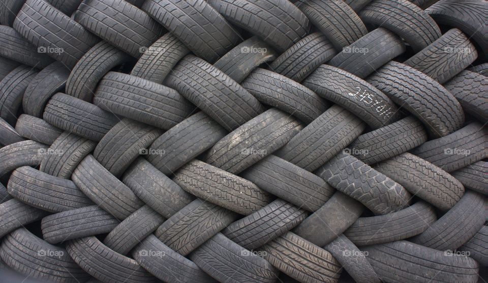 Lines of tubeless tires in the shape of a wall on the street outside a tire shop in the borough of Queens, New York City on March 10, 2014.
