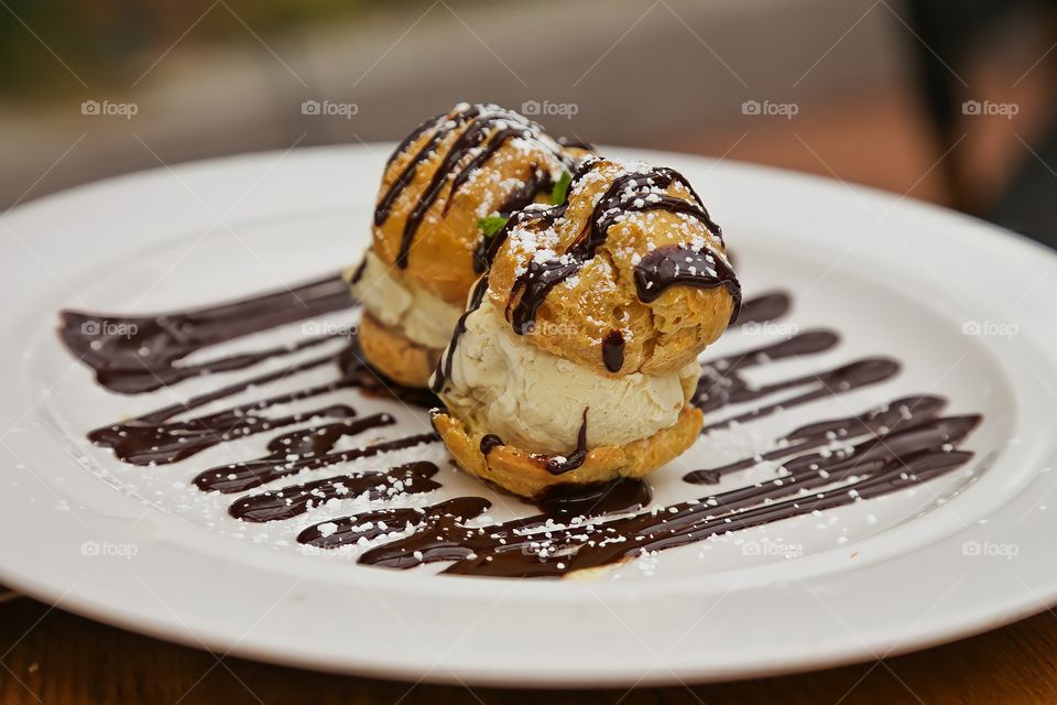 A delicious dessert of profiteroles with chocolate. Photograph taken on September 19 in a restaurant in Valladolid. Spain.