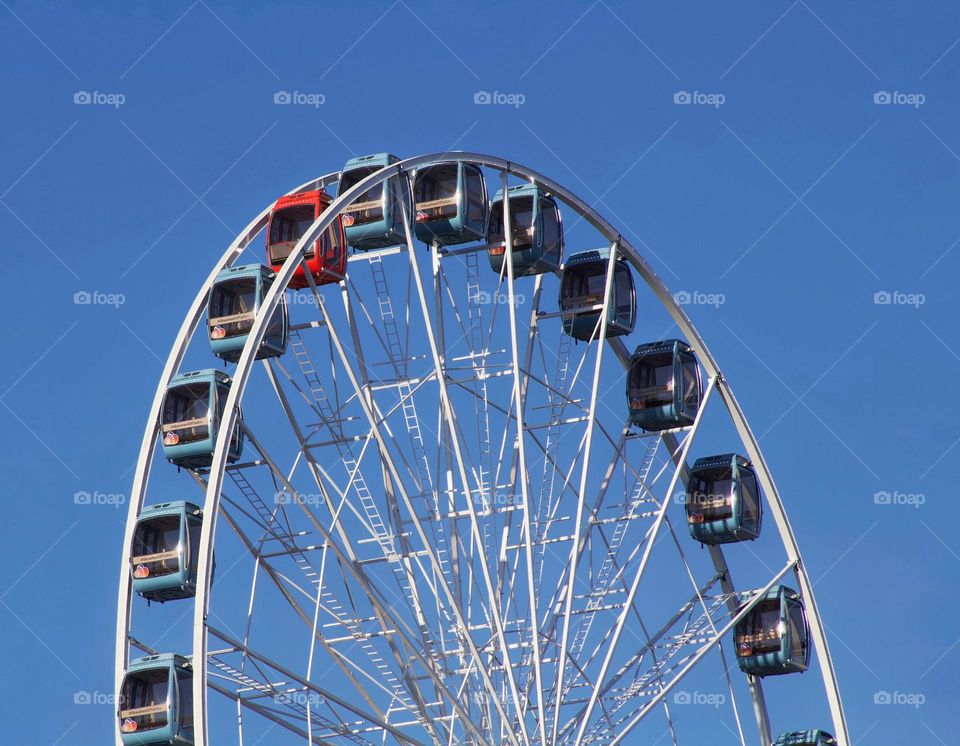 The red cabin amongst all the blue cabins on a Ferris wheel in Tallinn, Estonia.