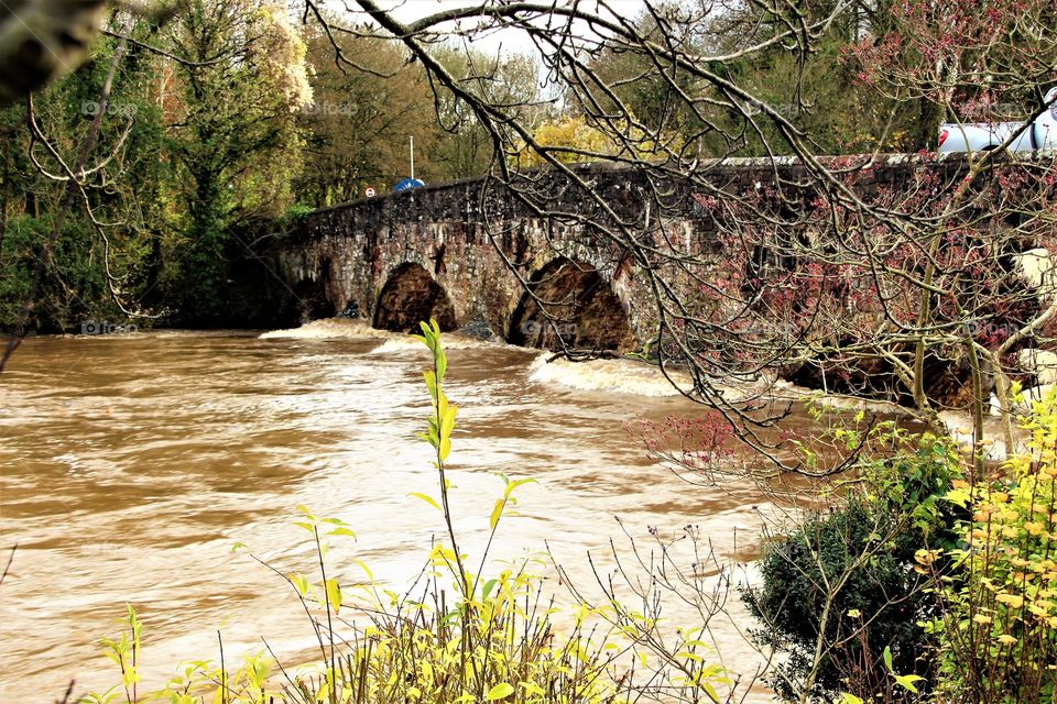 Bickleigh bridge being deluged with a raging torrent of water