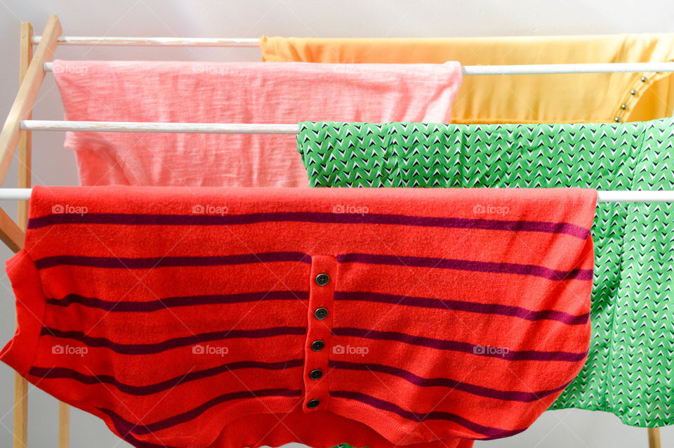 Colorful shirts hanging on a clothes rack to dry
