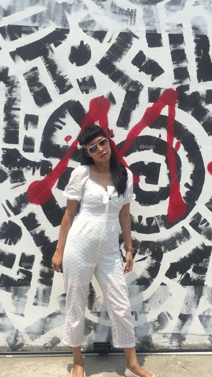 Asian girl makes a pose on graphical wall