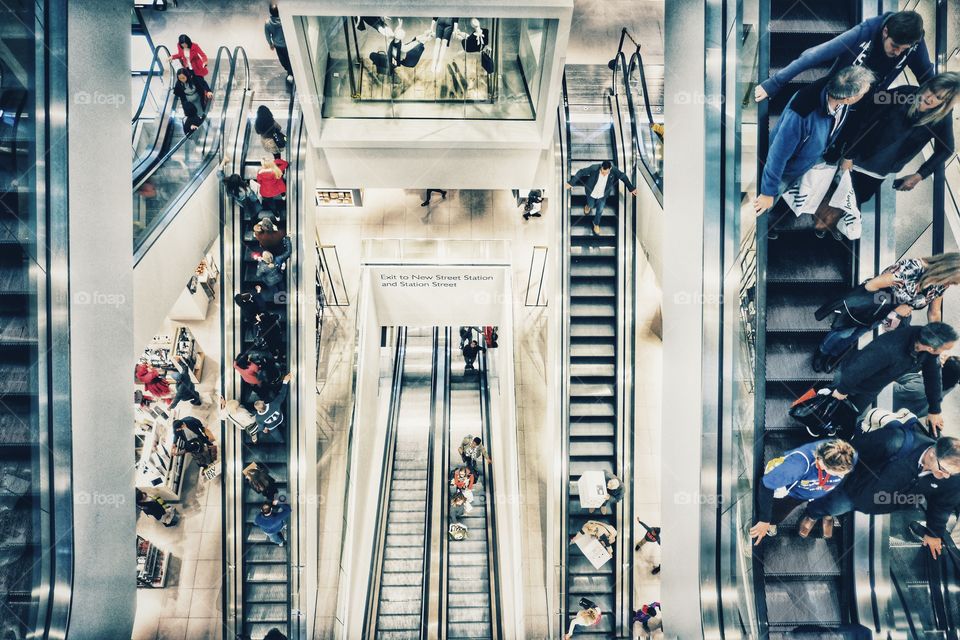 Store. Inside a department store in a shopping mall with people moving between floors on escalators . 