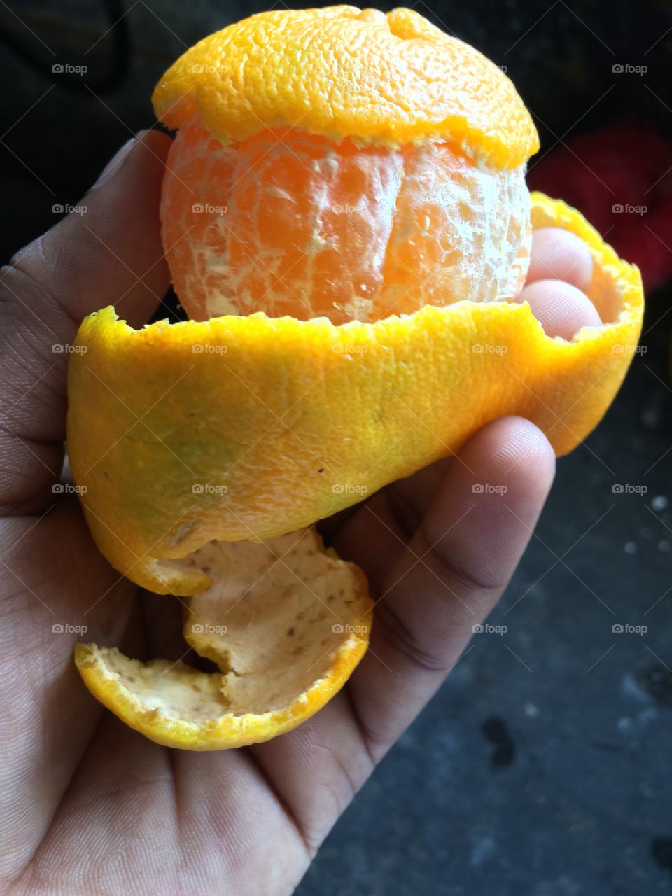 Close-up of hand peeling orange