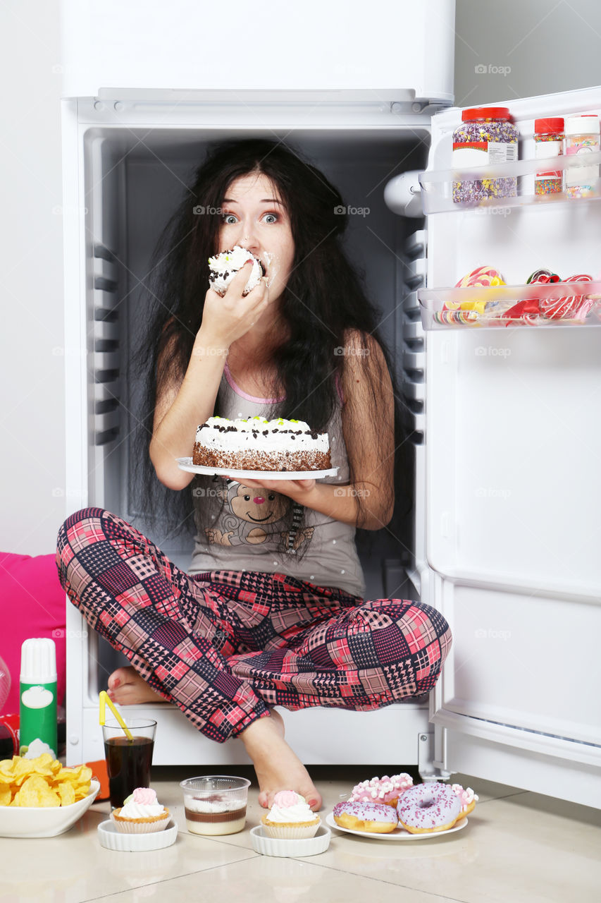 Girl in the fridge with with sweets