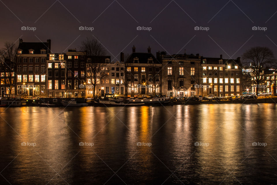 Illuminated building reflected in lake