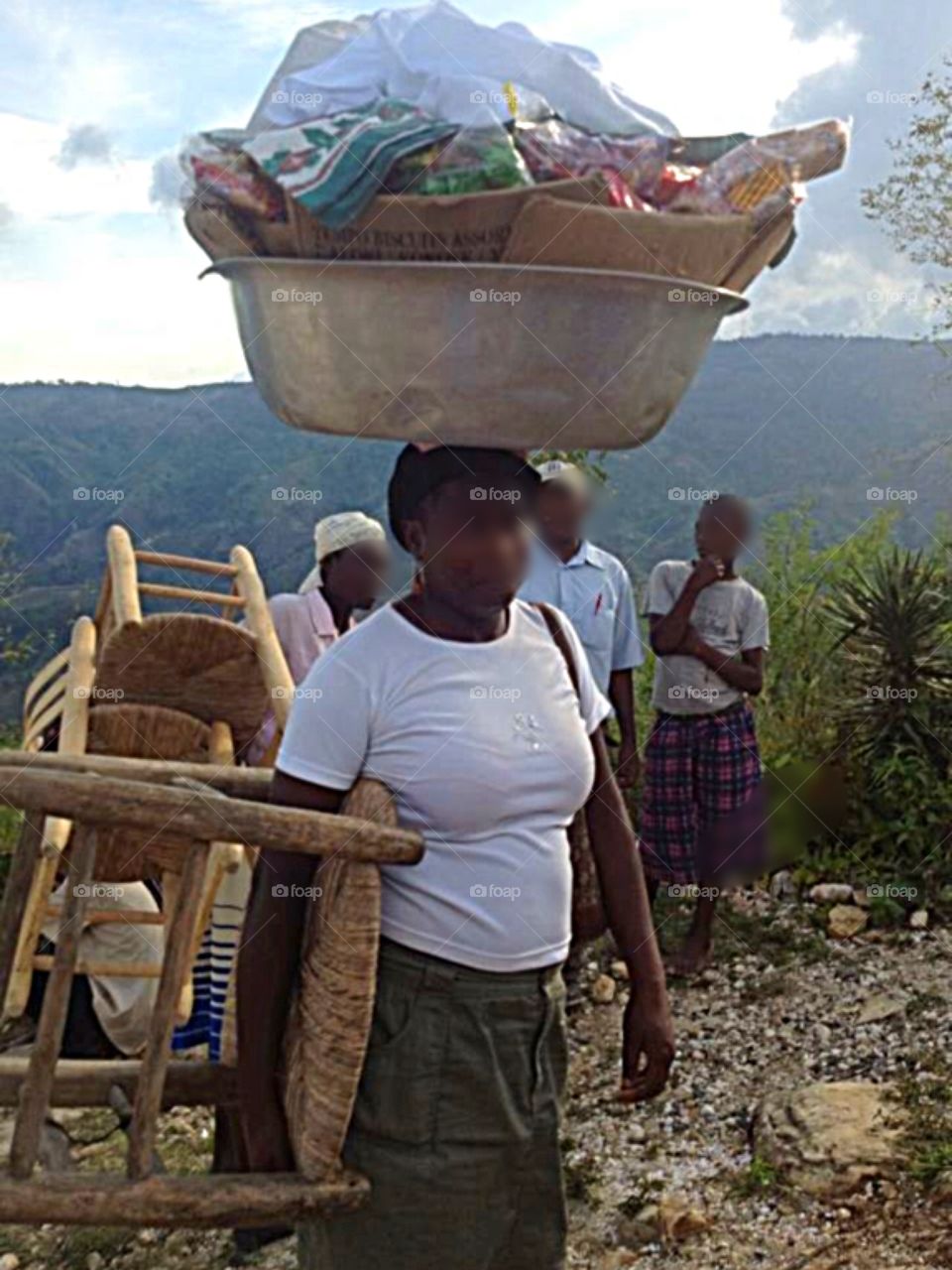 Haitian people working.  Women carry things on their heads in baskets.