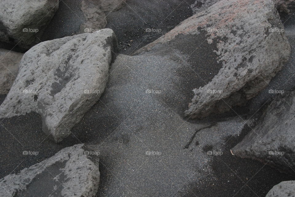 Grey stones and black sand.