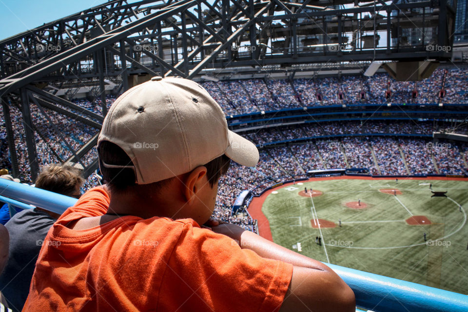 Cute little boy is watching a baseball game