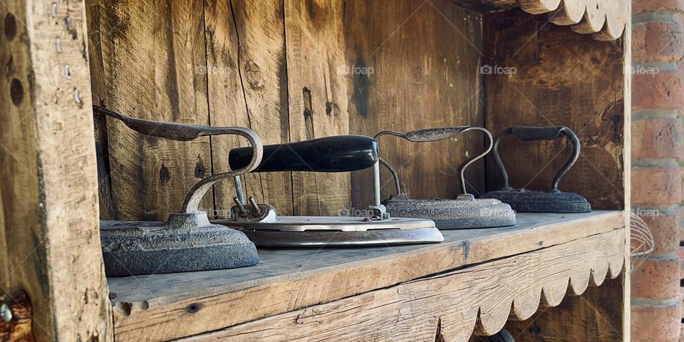 Wooded Shelf with Old Ironing Machines 