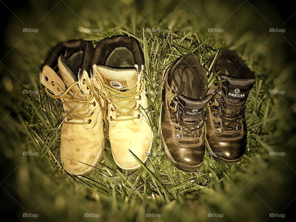 Two pair of hiking boots. Mine and my husbands setting in the grass.