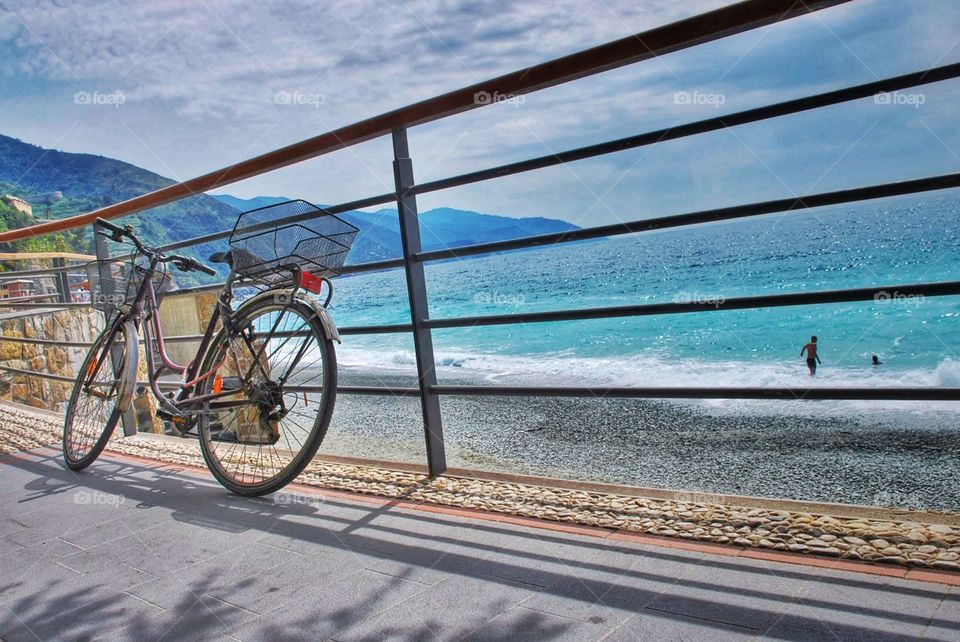 Bike and beach. A bike sits along a railing above a beach and beautiful aqua blue ocean 