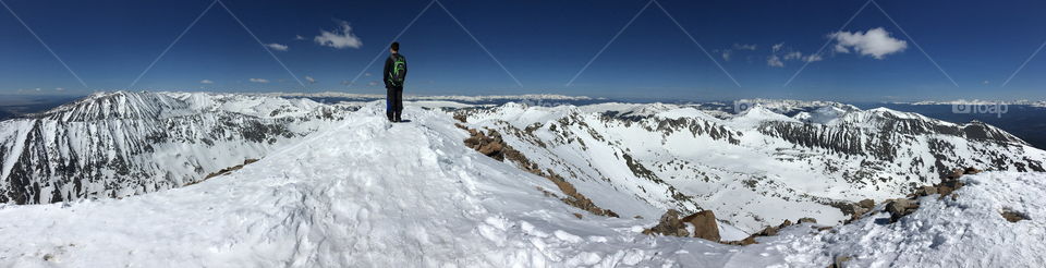 A photographer standing on top of a Colorado 14er Quandary Peak