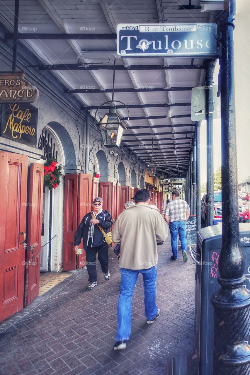 People walking about around Toulouse Street, French Quarter, New Orleans, Louisiana, USA.