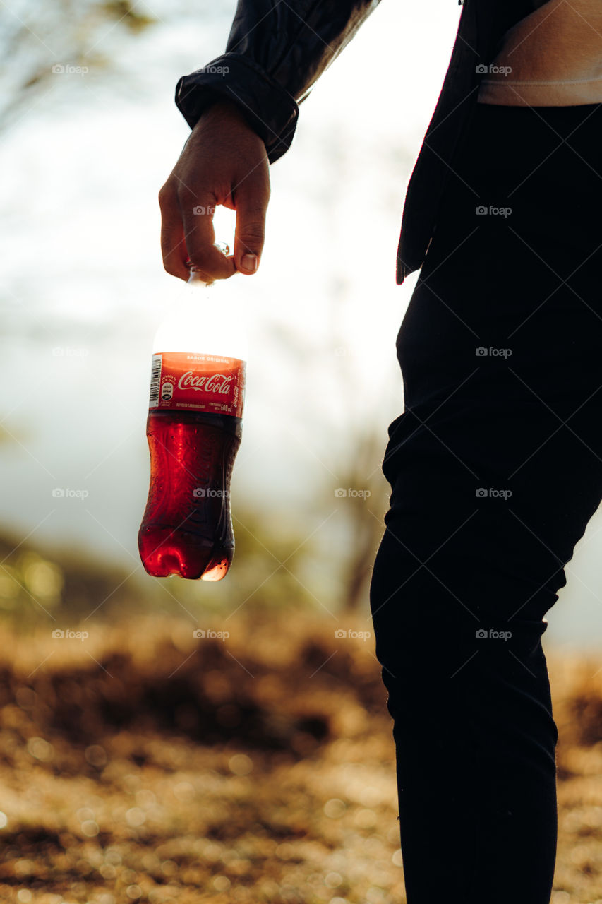 Person enjoying a delicious Coca Cola on a very sunny day