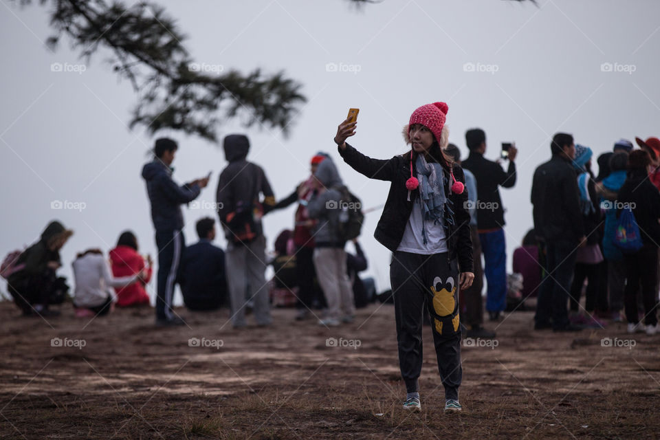 Tourist female taking a selfie at the cliff