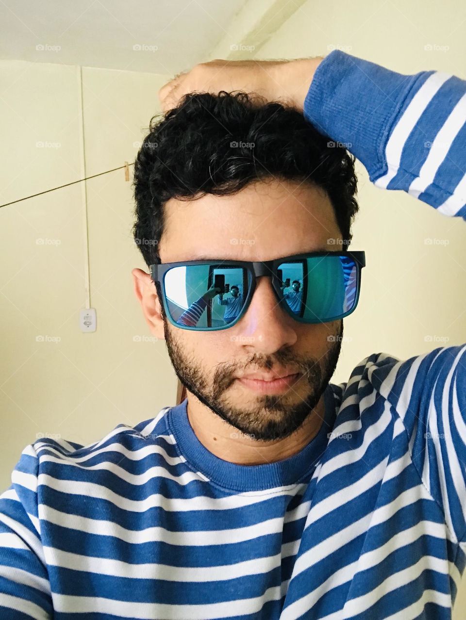 Handsome young man with beard and glasses taking selfie