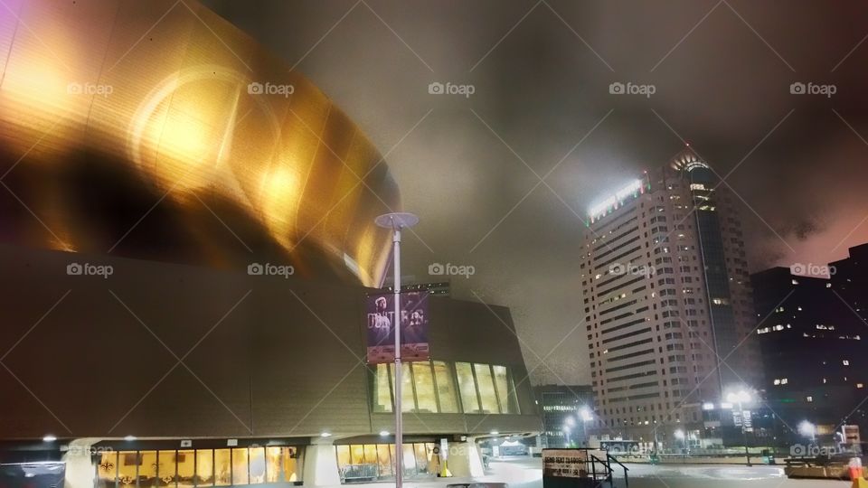 City skyline by night at the Mercedes-Benz Superdome, New Orleans, Louisiana, USA. A rainy and foggy evening.