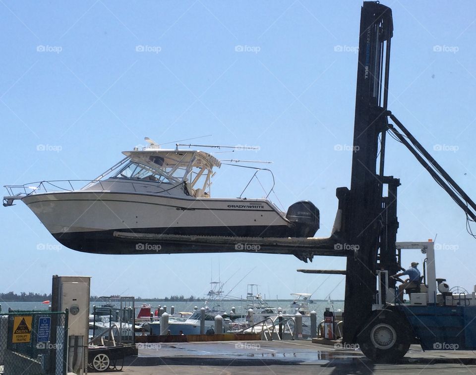 Boat being lifted out of the water for dry store at a marina 