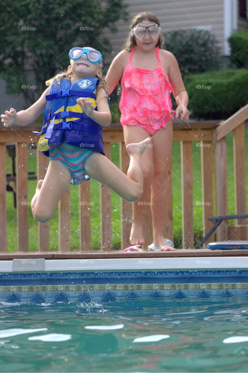 Little girl jumping in swimming pool