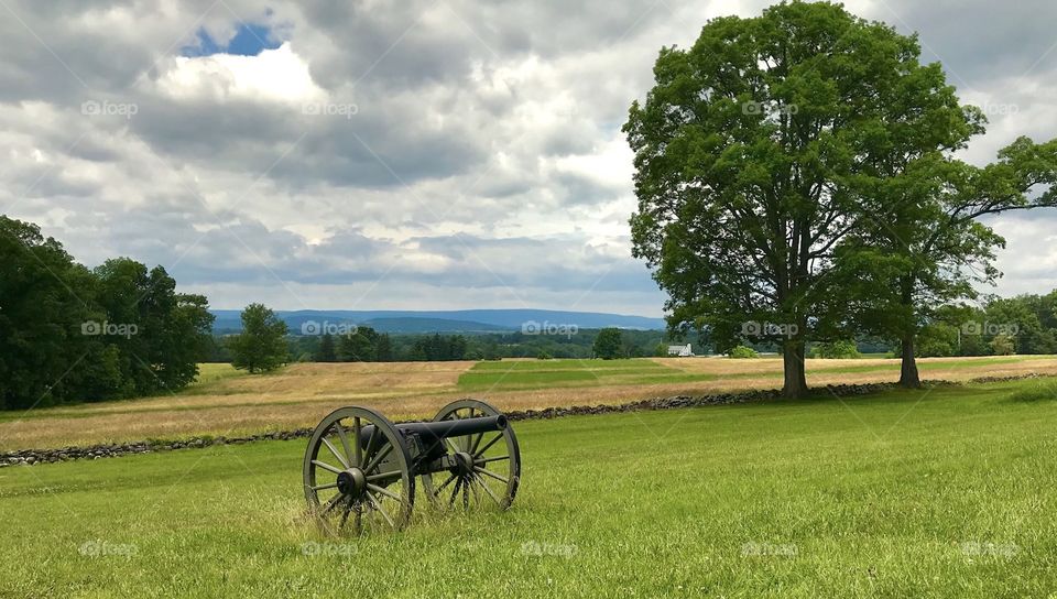 Cannon in the middle of an open field on a cloudy day