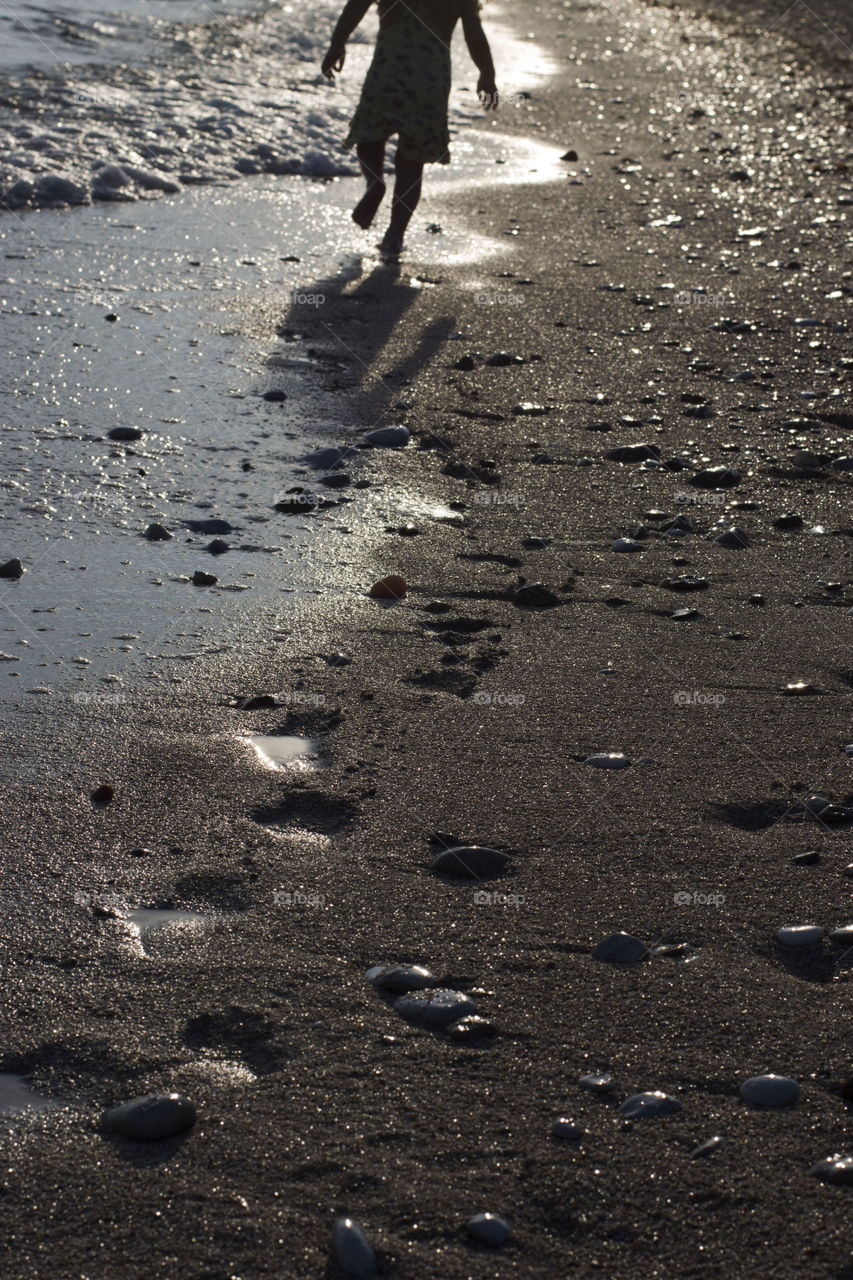 beach at sunset. sandy beach with pebbles at sunset