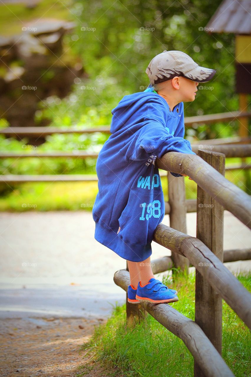 Boy . A boy leaning on a fence in his fathers hood