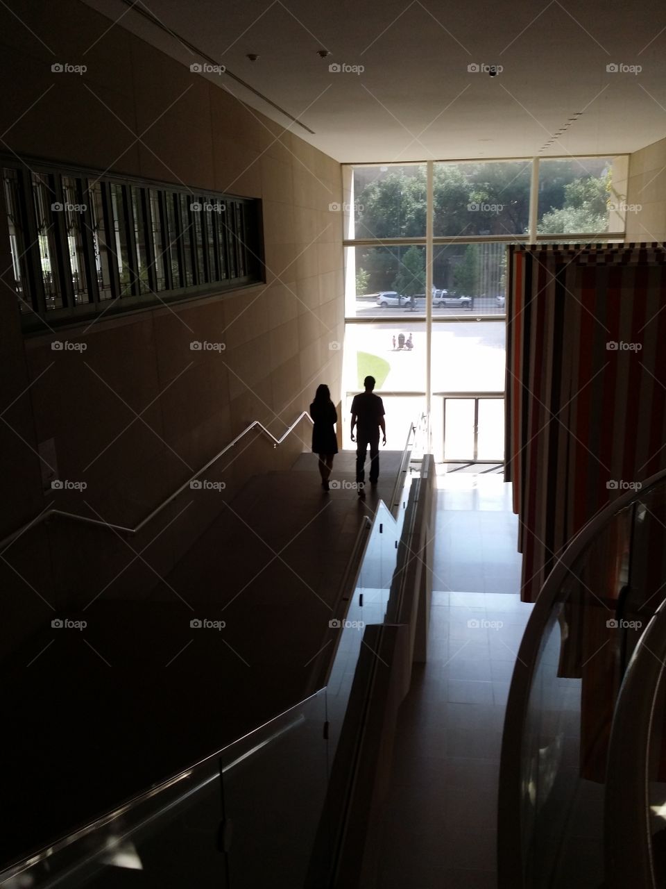 A man and a woman walking down stairs inside in silhouette