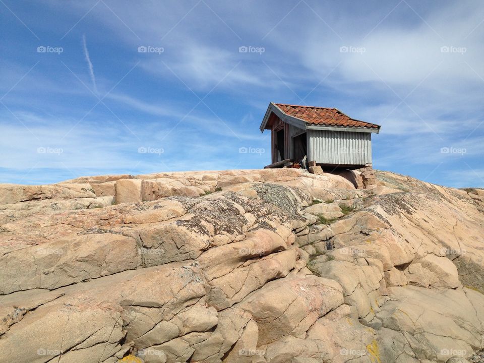Shed on the rocks. A small shed (fisherman's shed) on the top of a rock by the sea.
